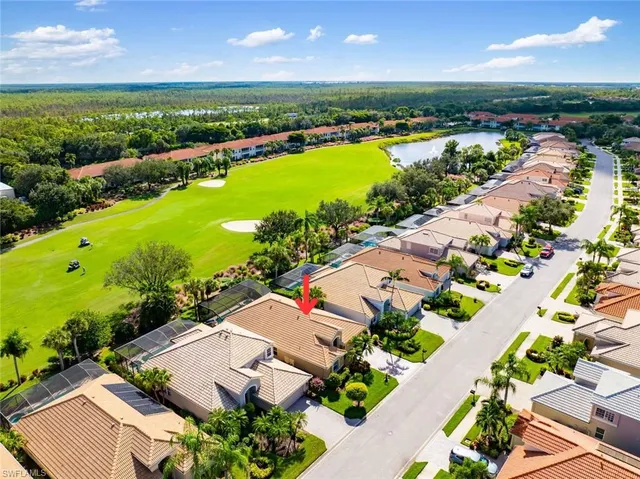 an aerial view of a city with lots of residential buildings ocean and mountain view in back