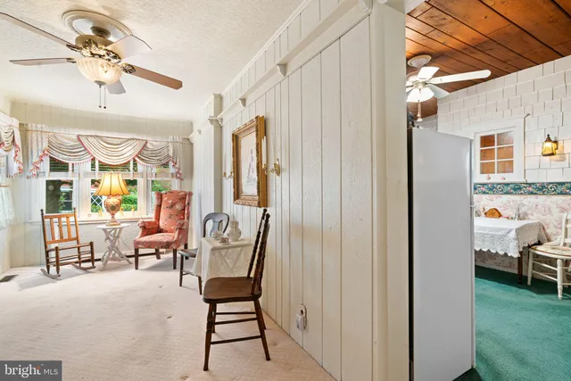 a bedroom with a bed and a dresser next to a window