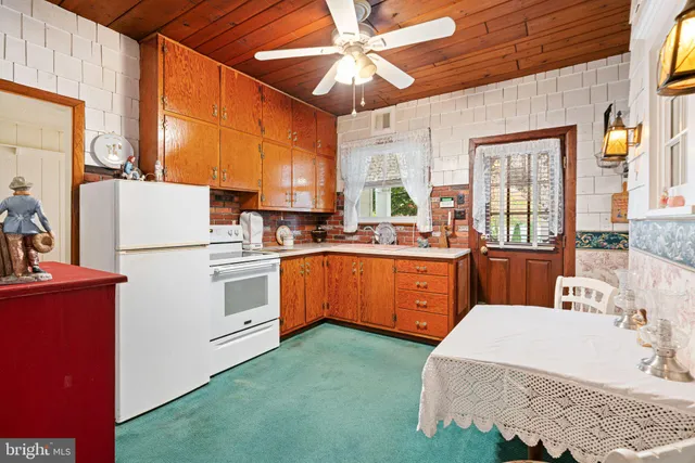 a kitchen with stainless steel appliances kitchen island granite countertop a refrigerator a stove and a wooden cabinets