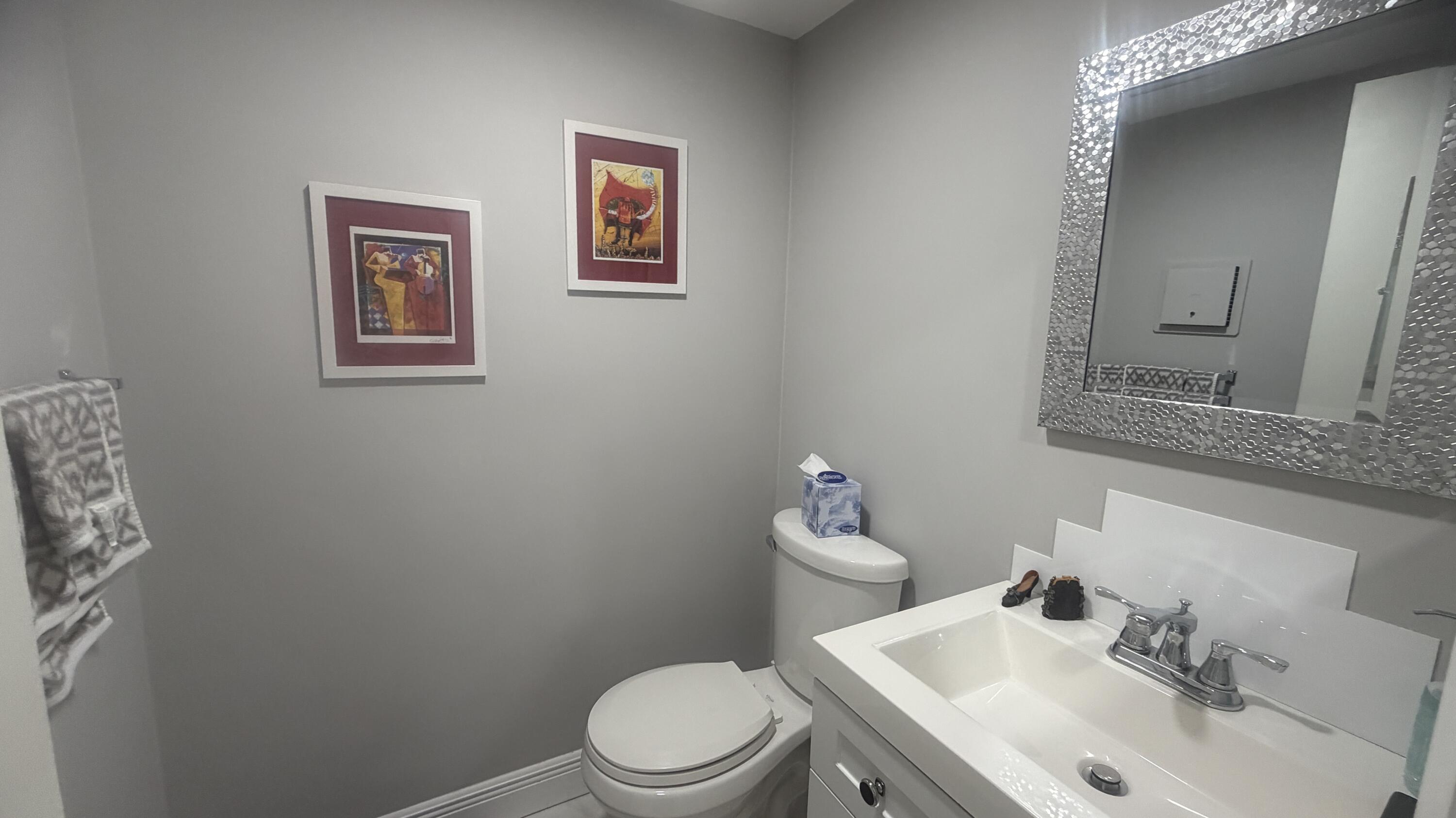 930 Normandy Trail Delray Beach, FL 33484 - Photo 12 of 34 a bathroom with a toilet sink and mirror