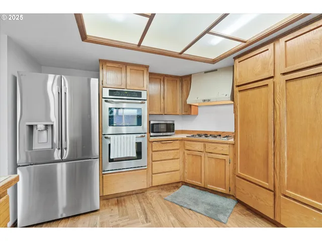 a kitchen with stainless steel appliances a refrigerator and a stove top oven