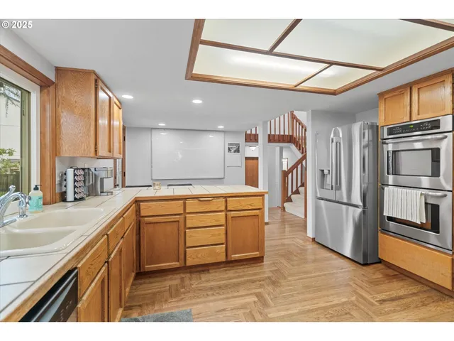 a kitchen with stainless steel appliances granite countertop a refrigerator a sink and a stove