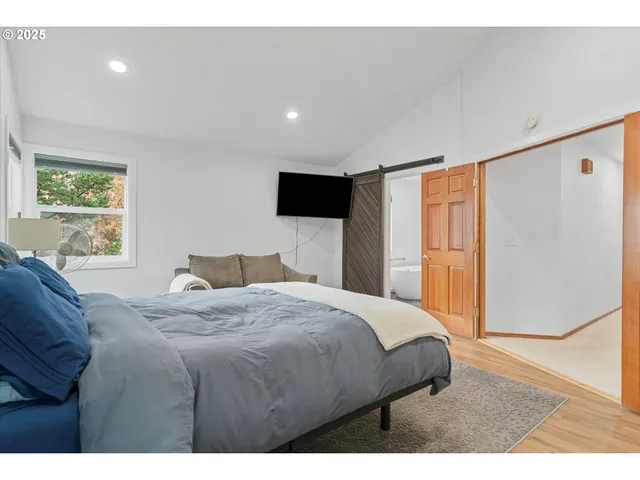 a bedroom with a bed and a refrigerator