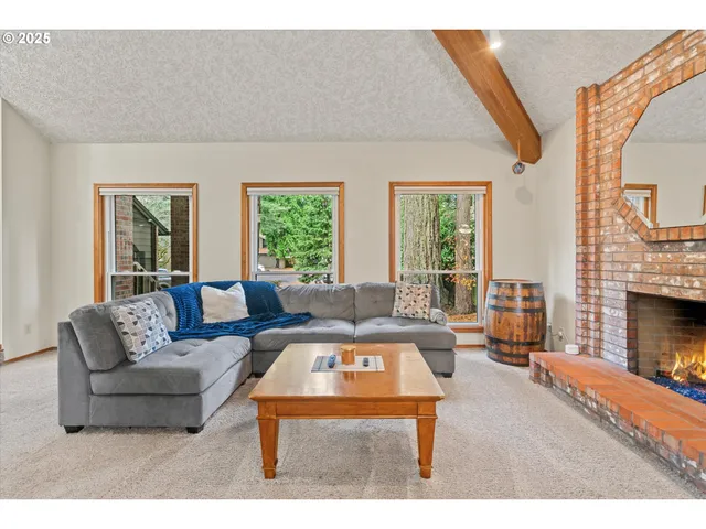 a living room with furniture a fireplace and a large window