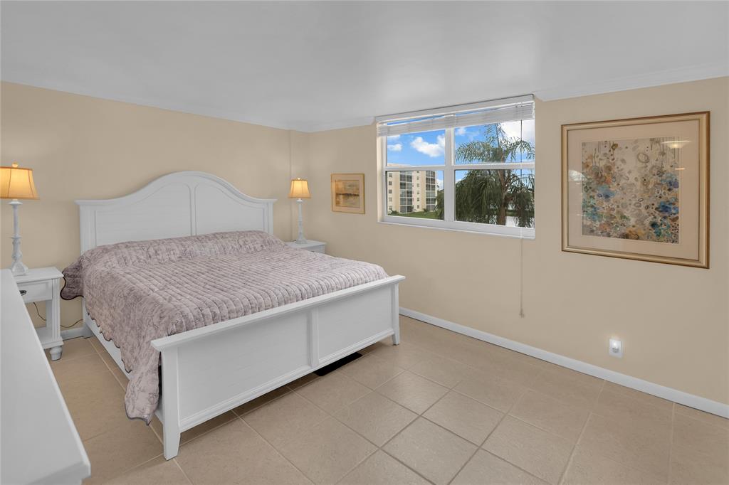 321 Southeast 3rd Street, Unit 307 Dania Beach, FL 33004 - Photo 12 of 21 a bedroom with a bed and a painting on the wall