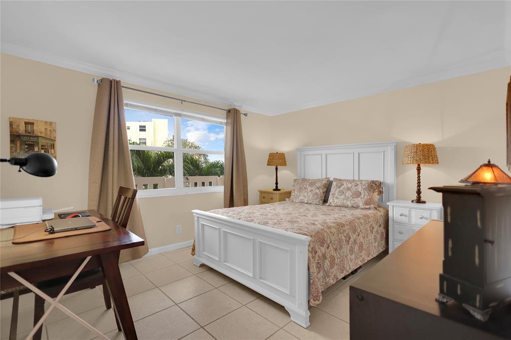 321 Southeast 3rd Street, Unit 307 Dania Beach, FL 33004 - Photo 14 of 21 a bedroom with a bed and a table in it