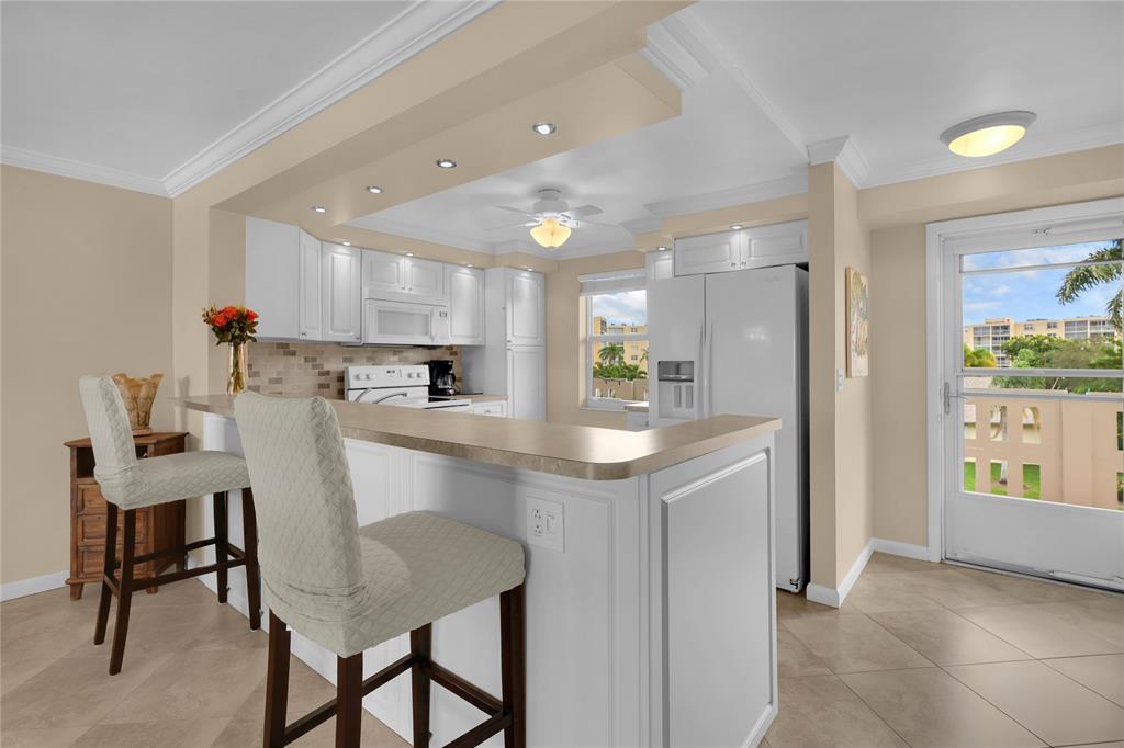321 Southeast 3rd Street, Unit 307 Dania Beach, FL 33004 - Photo 3 of 21 a kitchen with a dining table chairs and refrigerator