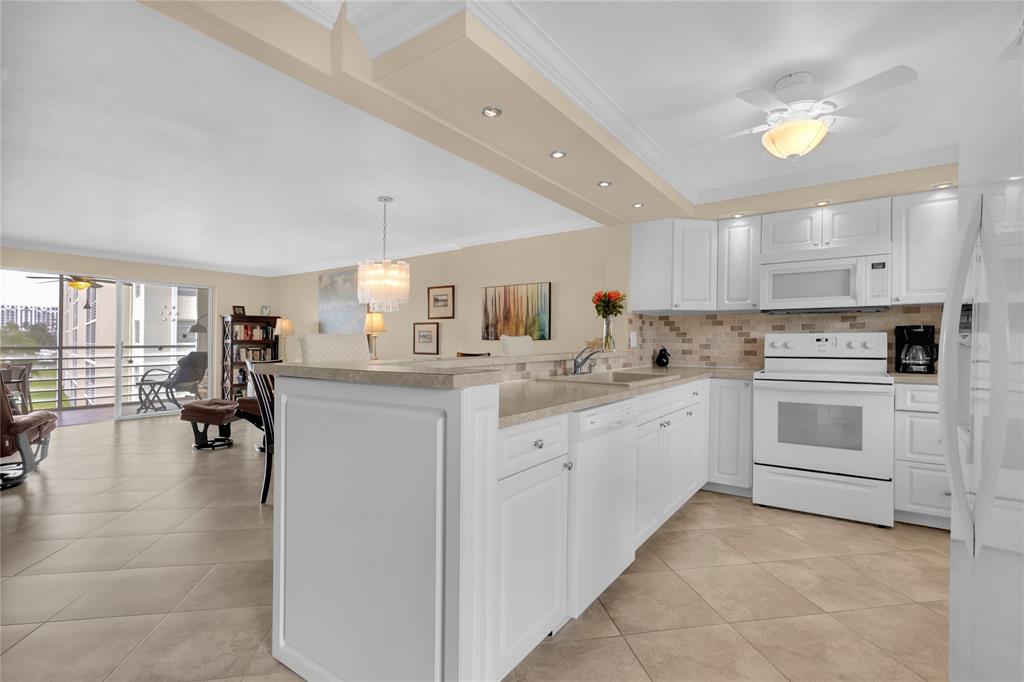 321 Southeast 3rd Street, Unit 307 Dania Beach, FL 33004 - Photo 4 of 21 a kitchen with sink and white cabinets