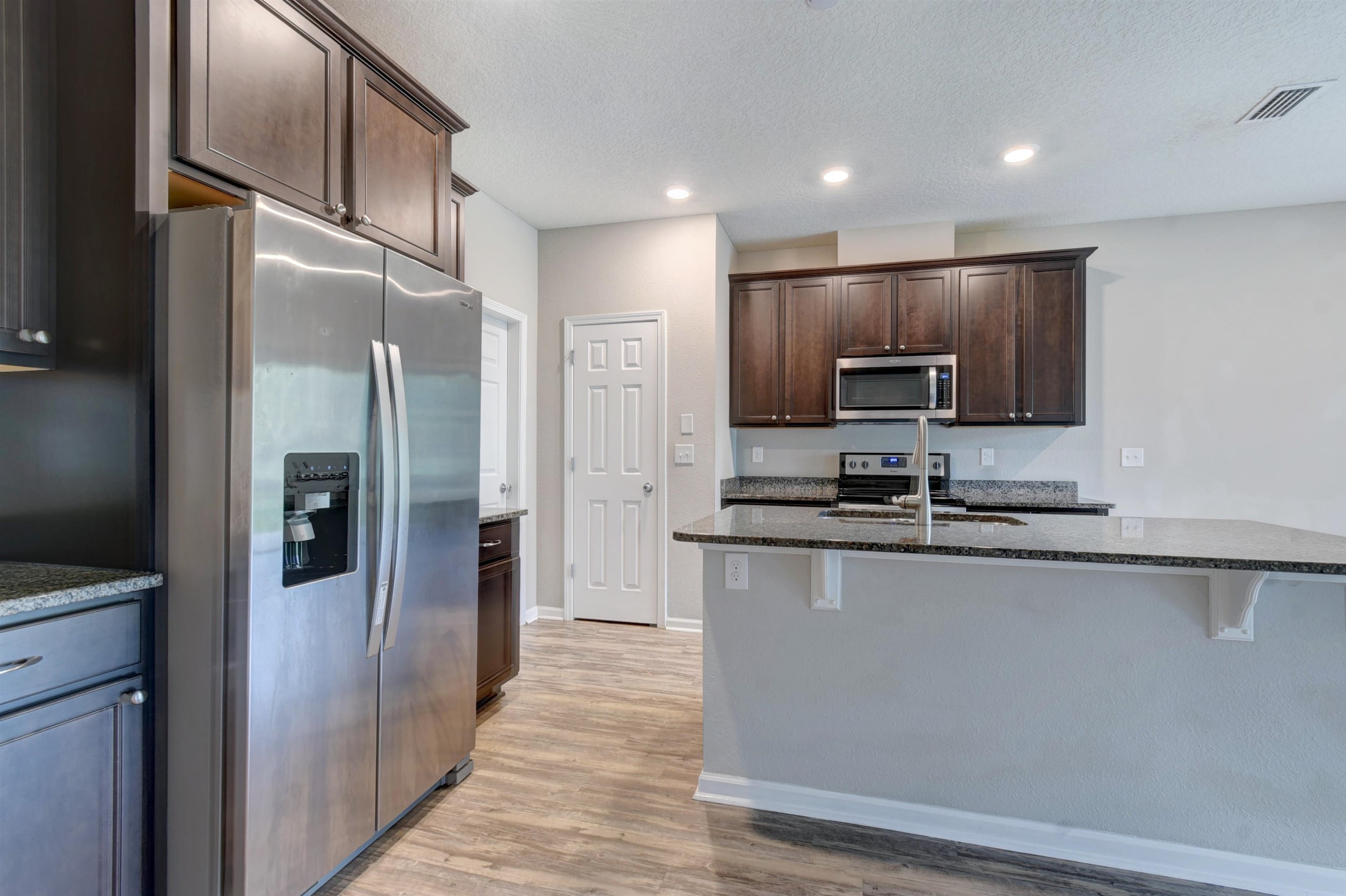 9 Bella Vita Way Ormond Beach, FL 32174 - Photo 6 of 36 a kitchen with stainless steel appliances granite countertop a refrigerator and a stove top oven
