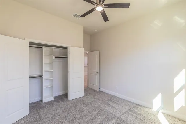 an empty room with a window and a fan