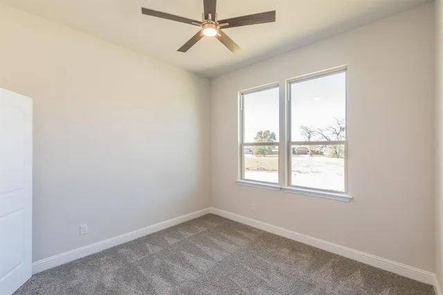 an empty room with closet and fan