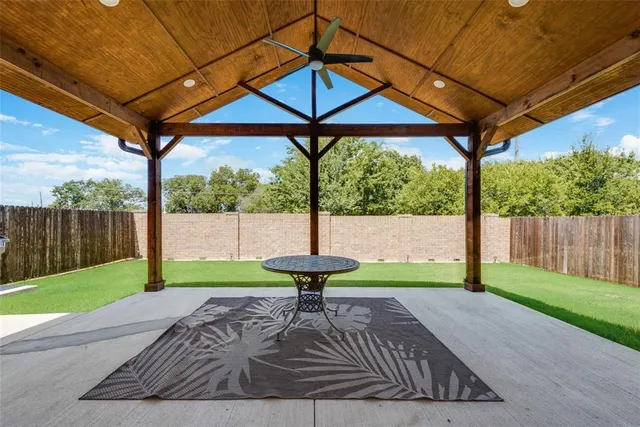 a view of a backyard with table and chairs under an umbrella