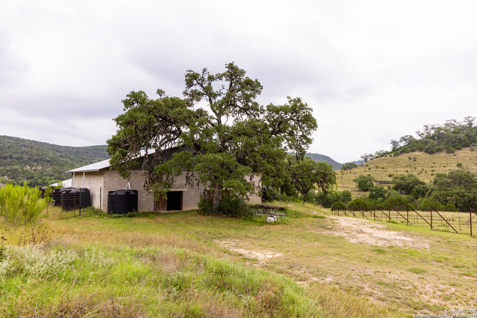 1600 Mickle Creek Road Medina, TX 78055 - Photo 8 of 18 a yellow house with trees in front of it