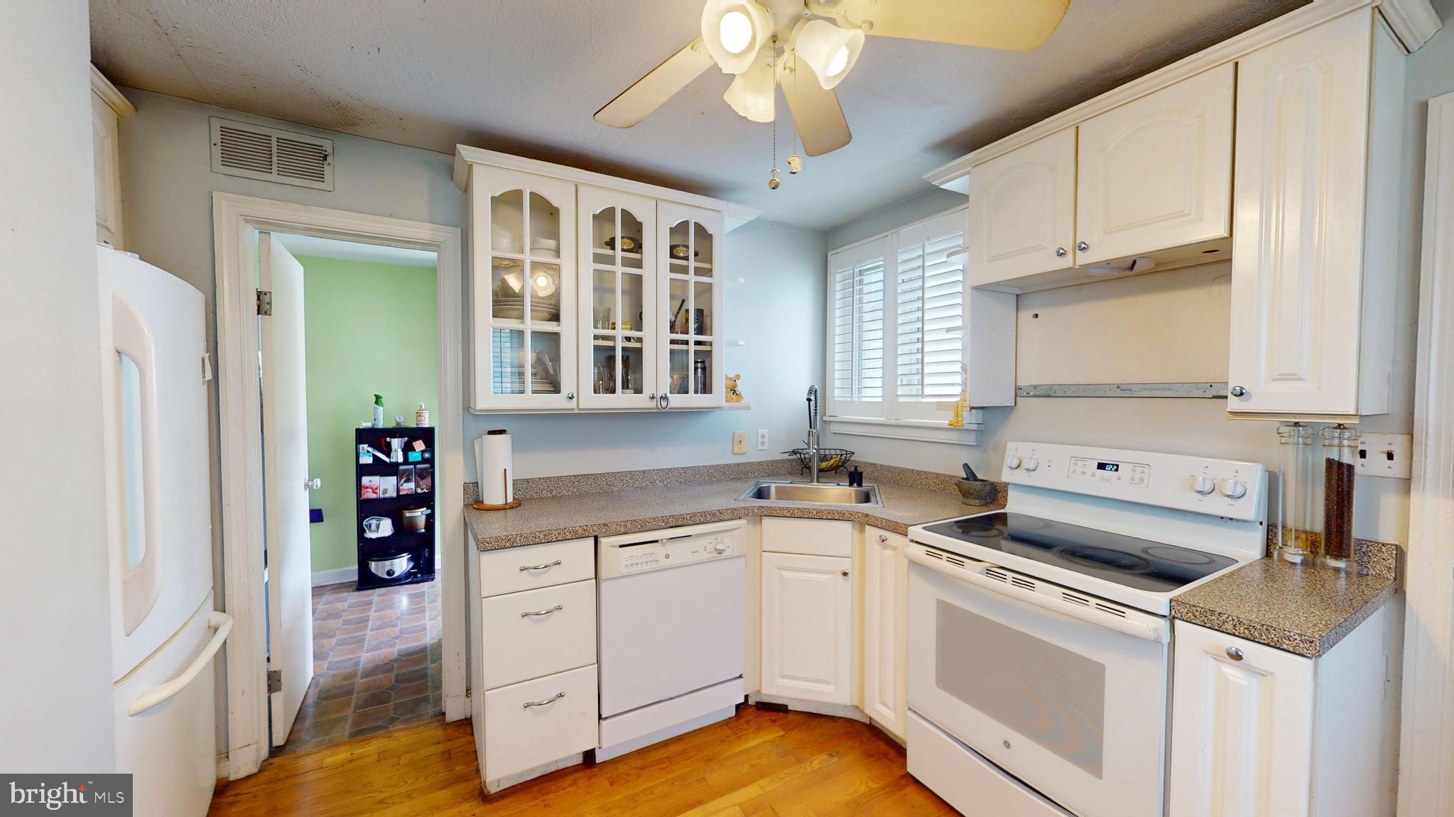 6103 Manor Road Clinton, MD 20735 - Photo 18 of 48 a kitchen with a stove cabinets and wooden floor