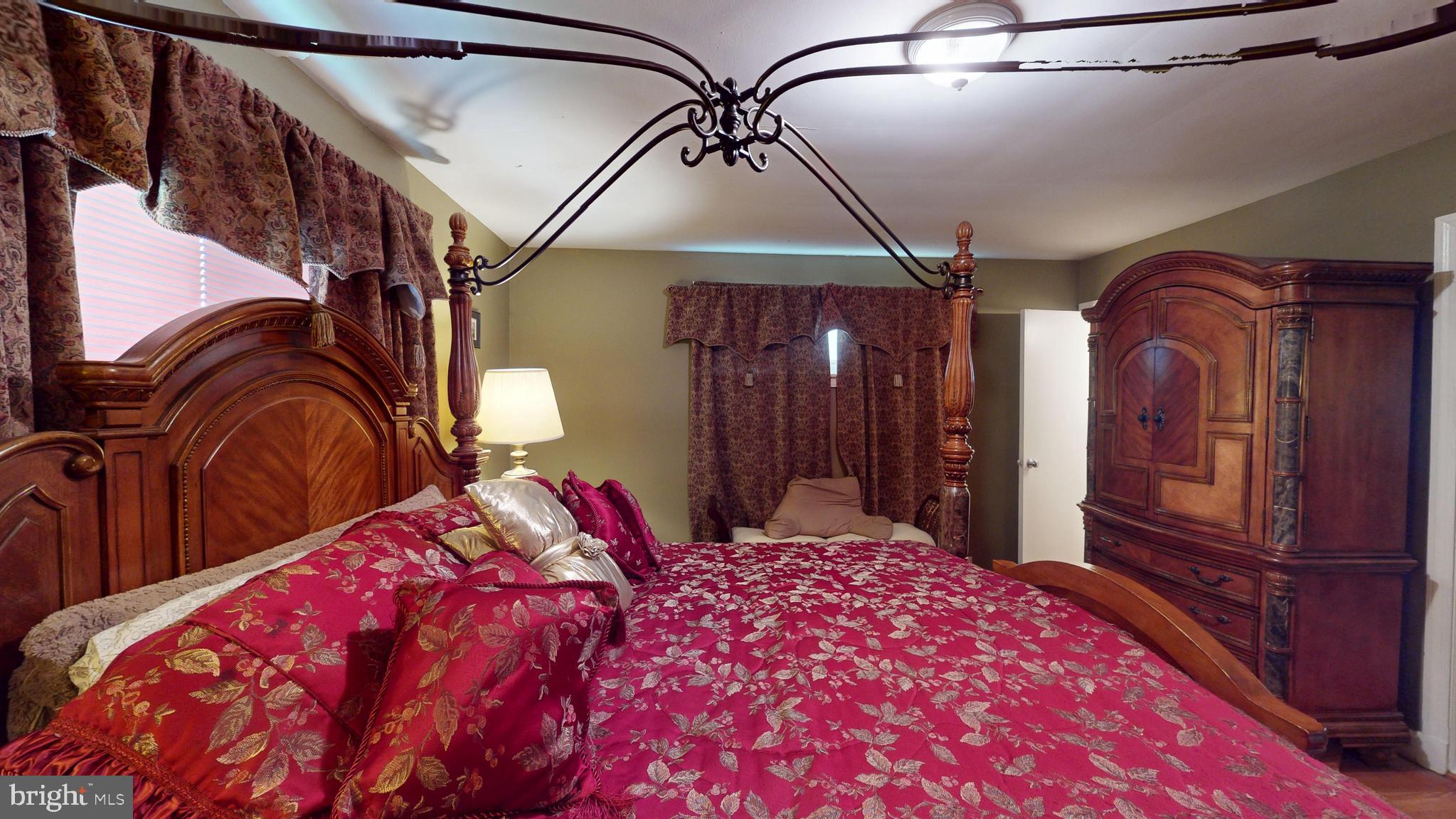 6103 Manor Road Clinton, MD 20735 - Photo 28 of 48 a bedroom with a large bed and a chandelier