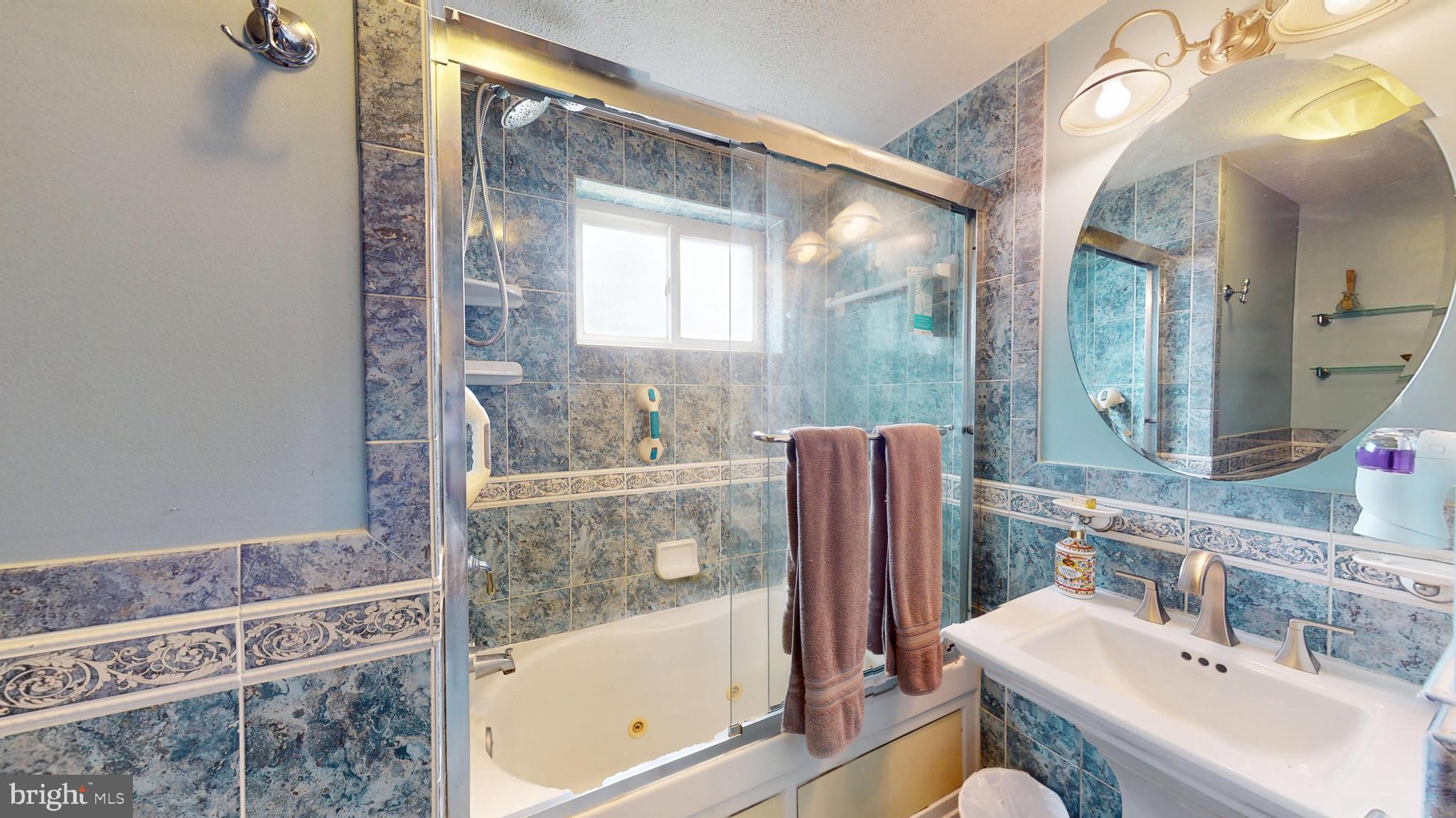 6103 Manor Road Clinton, MD 20735 - Photo 31 of 48 a bathroom with a sink mirror and a bathtub