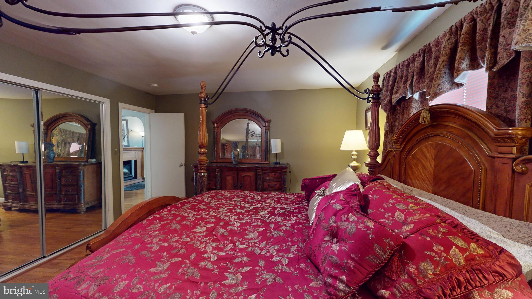 6103 Manor Road Clinton, MD 20735 - Photo 39 of 48 a bedroom with a large bed and a chandelier