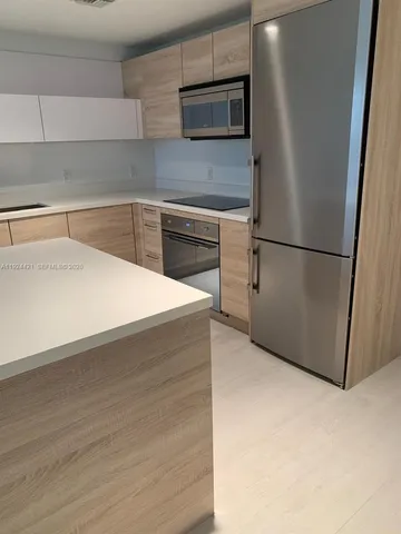 a kitchen with a refrigerator sink and cabinets