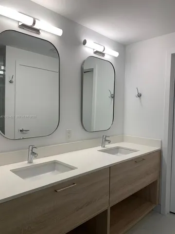 a bathroom with double vanity sinks and a mirror