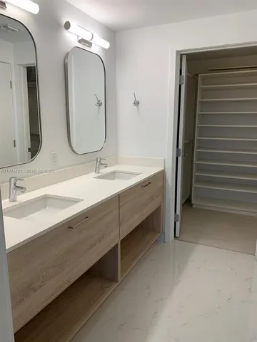 a bathroom with a double vanity sink and a mirror