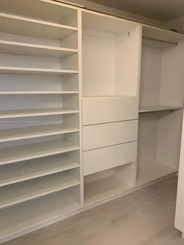 a view of walk in closet with empty racks