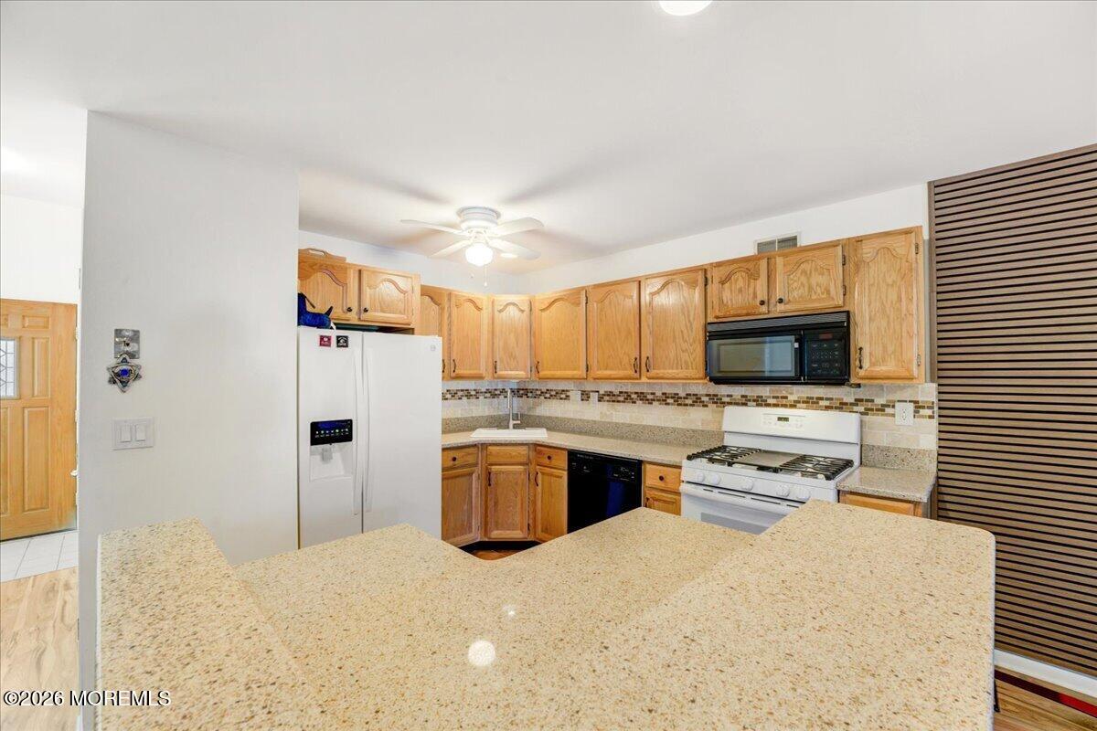 46 Stony Hill Road Jamesburg, NJ 08831 - Photo 11 of 23 a kitchen with stainless steel appliances kitchen island granite countertop a refrigerator a stove top oven a sink dishwasher and wooden floor