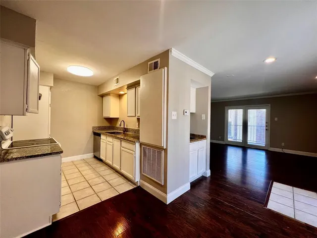 a kitchen with granite countertop a refrigerator and a stove top oven