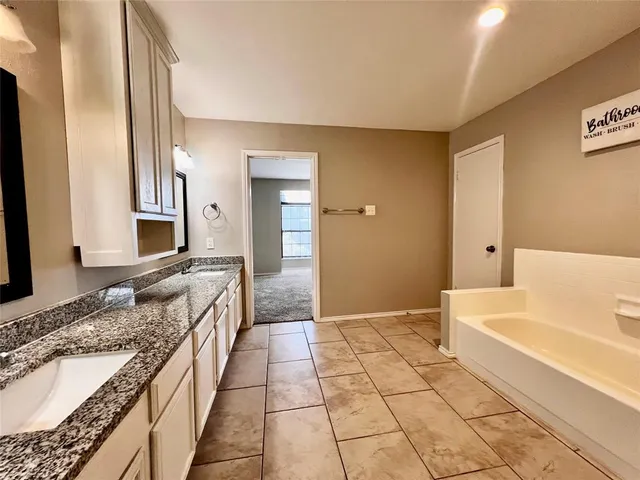 a bathroom with a granite countertop toilet sink and mirror