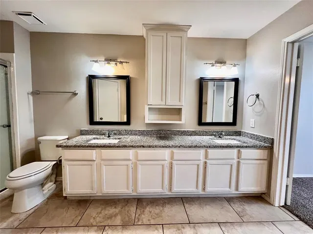 a bathroom with a granite countertop tub sink and mirror