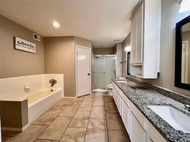 a spacious bathroom with a granite countertop tub sink and mirror