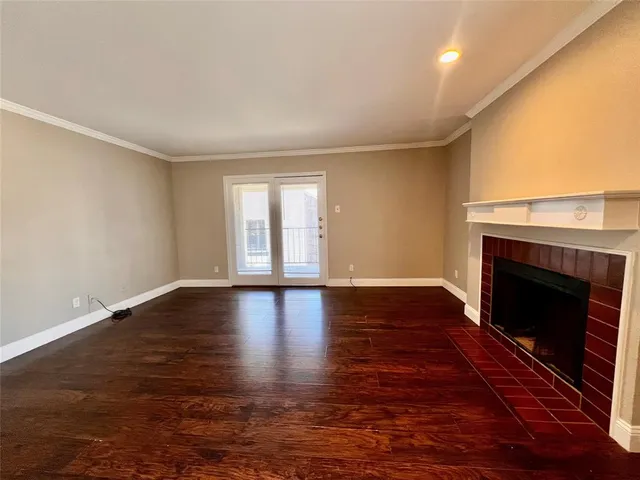 a view of empty room with wooden floor and fireplace