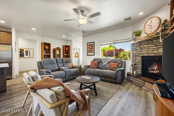 a living room with furniture a fireplace and a large window