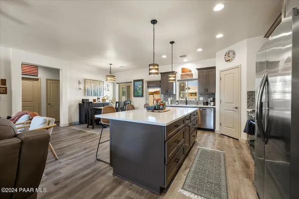 a kitchen with stainless steel appliances granite countertop counter top space a sink wooden floor and kitchen view