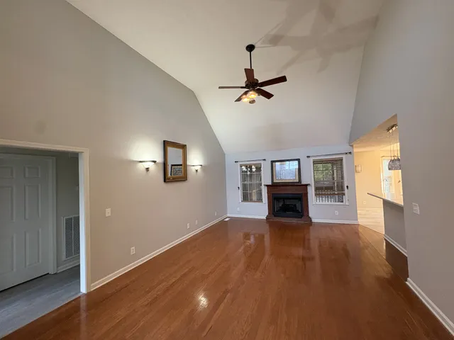 a view of empty room with wooden floor and fireplace