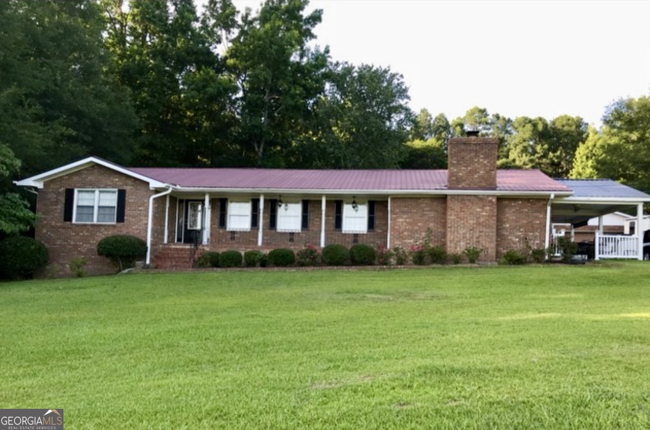 1390 Athens Road Crawford, GA 30630 - Photo 1 of 1 a front view of a house with a garden