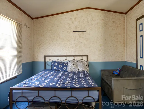 a bedroom with a bed a dresser and a window