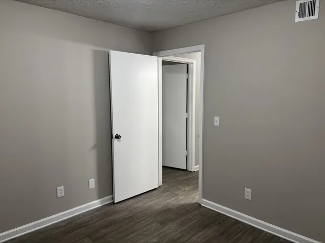 a view of an empty room with wooden floor