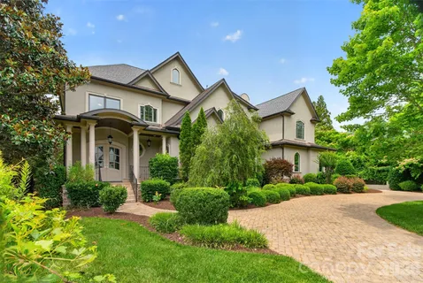 a front view of a house with a yard and potted plants