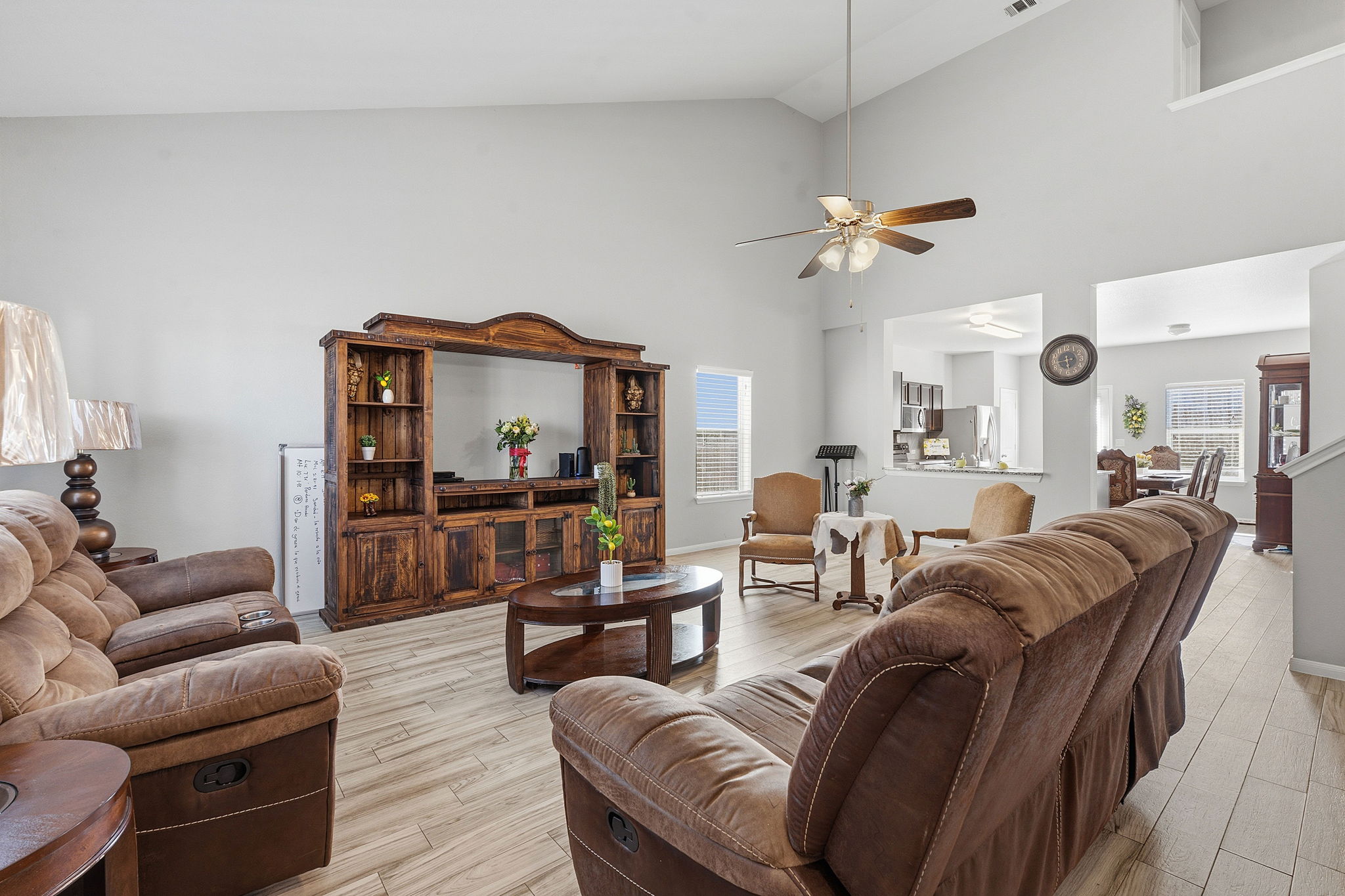 15101 Shell Bark Cove Austin, TX 78724 - Photo 4 of 26 Vaulted ceiling living area featuring wood-finish flooring, a ceiling fan with integrated lighting, and multiple windows