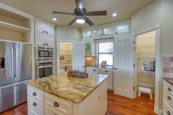 a kitchen with stainless steel appliances granite countertop a sink refrigerator and cabinets