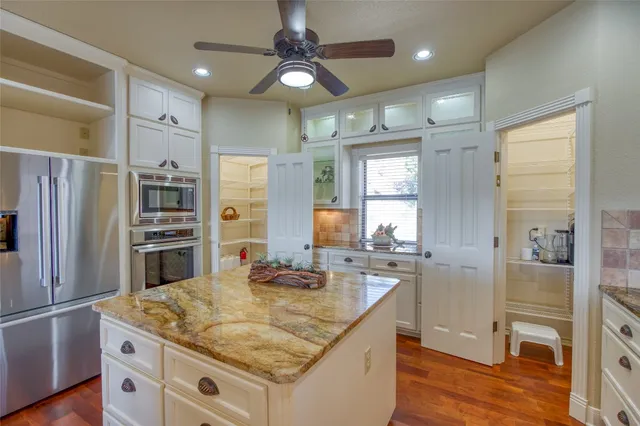 a kitchen with stainless steel appliances granite countertop a sink refrigerator and cabinets