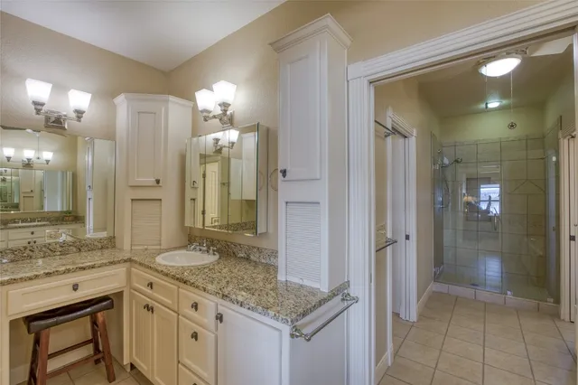 a bathroom with a granite countertop sink shower and a mirror