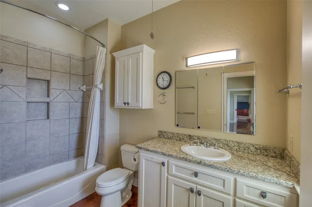 a bathroom with a granite countertop sink toilet and shower