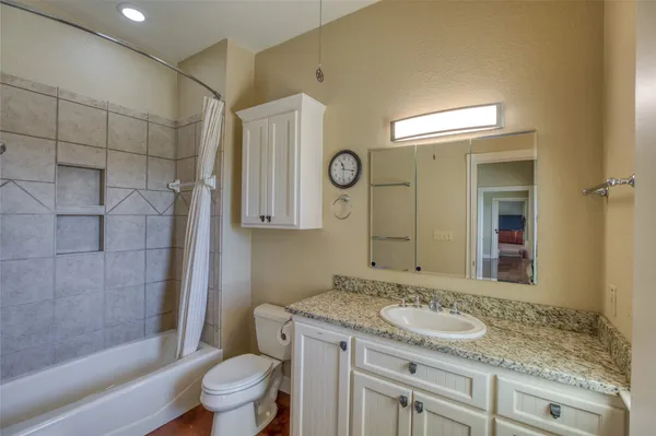 a bathroom with a granite countertop sink toilet and shower