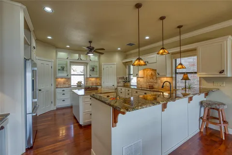 a kitchen with stainless steel appliances granite countertop a sink and a refrigerator