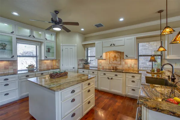 a kitchen with granite countertop a sink stainless steel appliances and cabinets