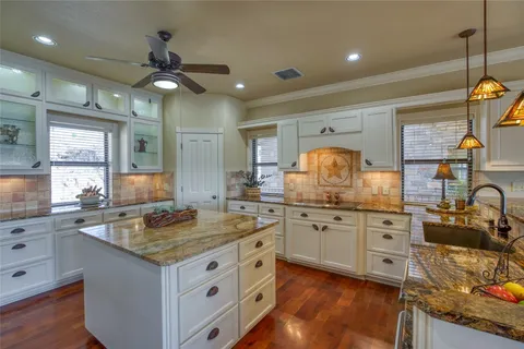 a kitchen with granite countertop a sink stainless steel appliances and cabinets