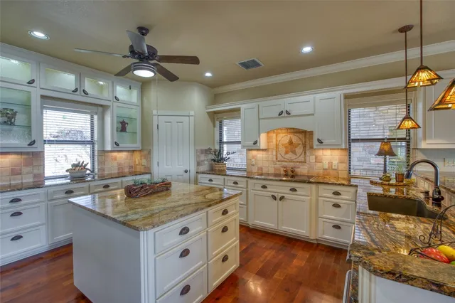 a kitchen with granite countertop a sink stainless steel appliances and cabinets