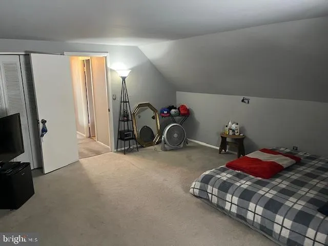 a bedroom with a bed and a flat tv screen on dresser