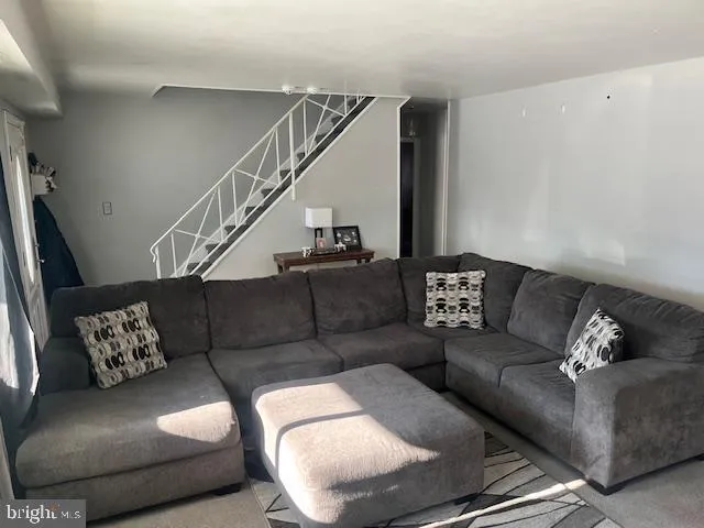 a living room with furniture and stairs
